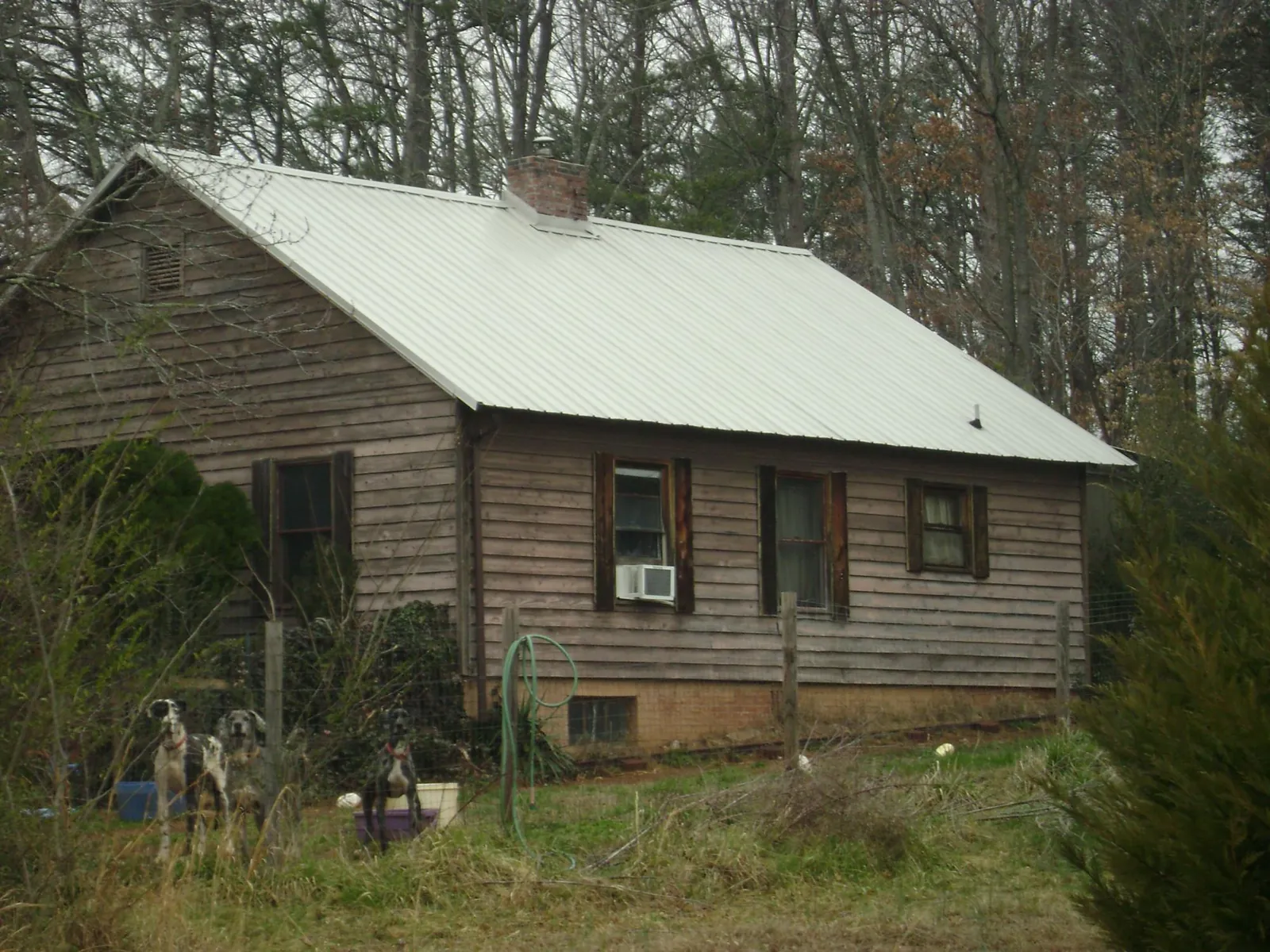 White metal roof on an old wood sided farmhouse, from a Metal Roof Installation job in Dudley